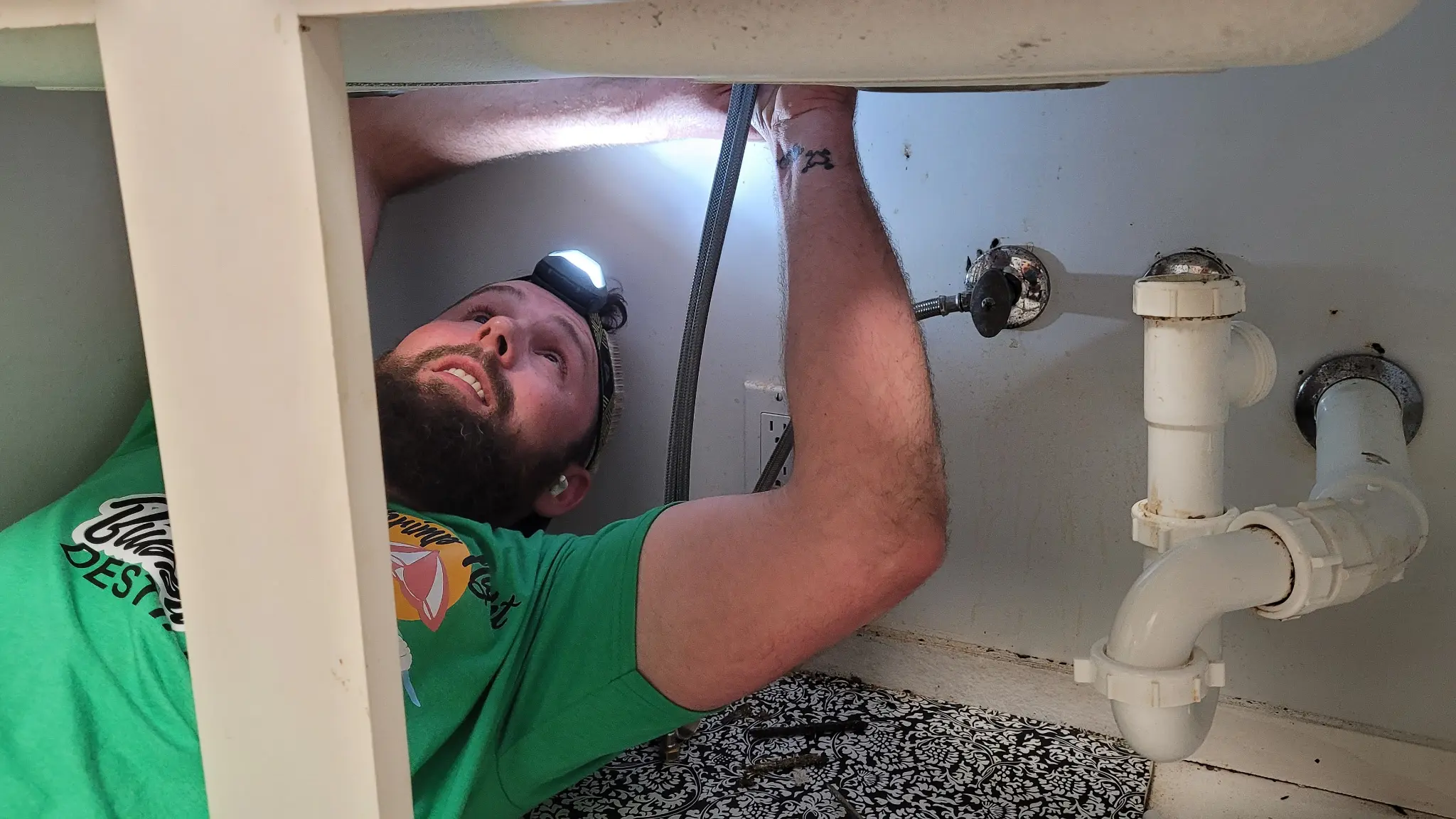 Professional plumber working under sink